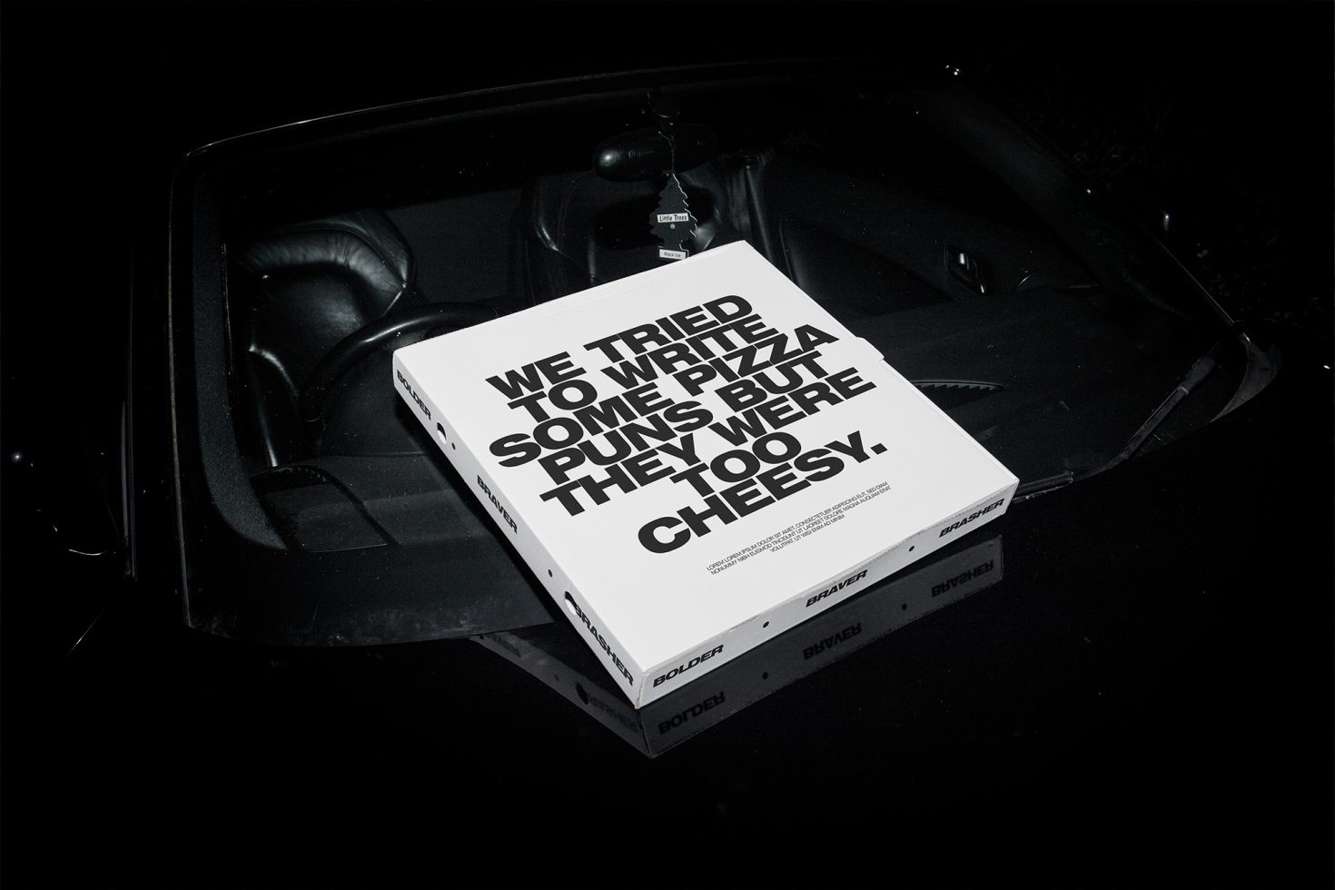 Creative pizza box mockup with clever typography, placed in a car setting for realistic design presentation, ideal for showcasing packaging designs.